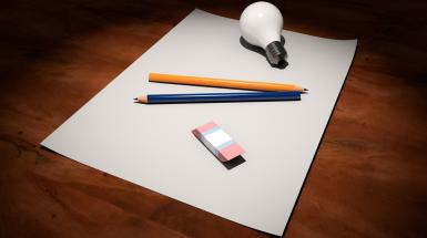 Image of pencil, eraser, and light bulb on blank sheet of paper