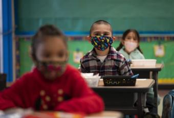 Kindergarteners inside classroom wearing masks